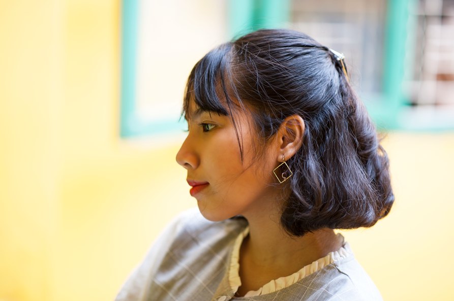 Brunette model wearing a gold sunburst clip in a low side bun