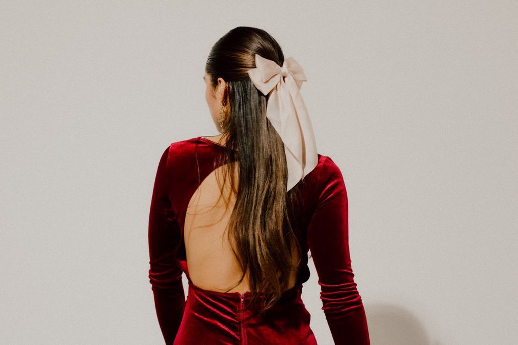 Modern styling of a 1940s velvet bow with a cashmere jumper and low chignon