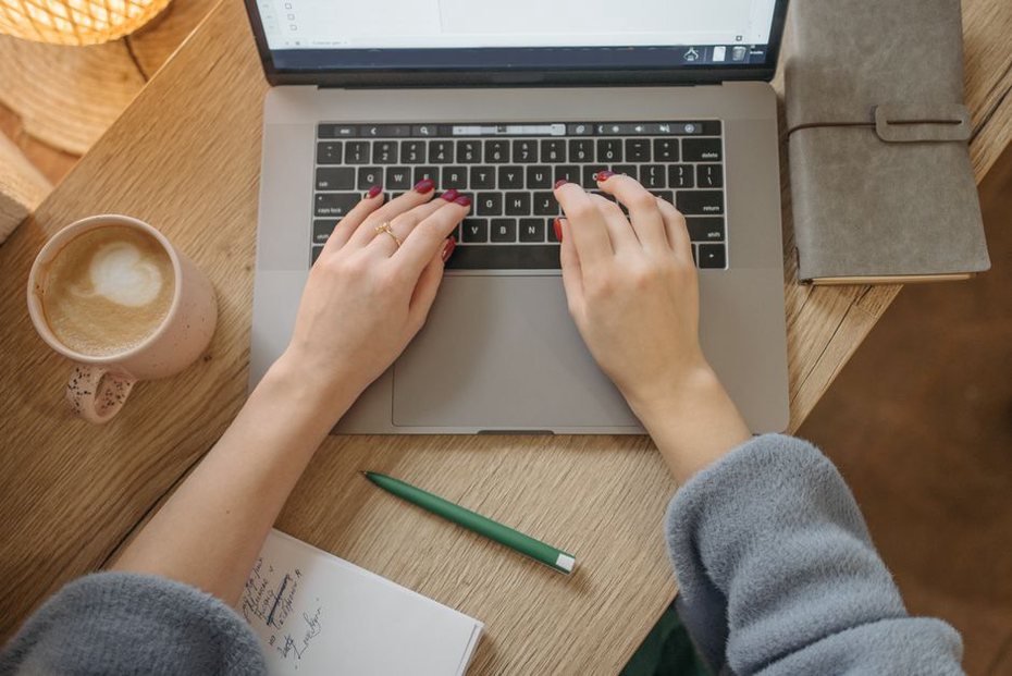 a blogger editing a feed file at a small desk with tea and reference books