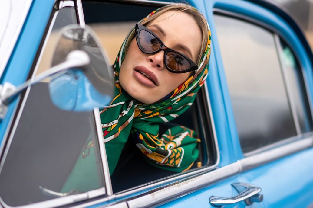 A patterned silk scarf frames a curled hairstyle