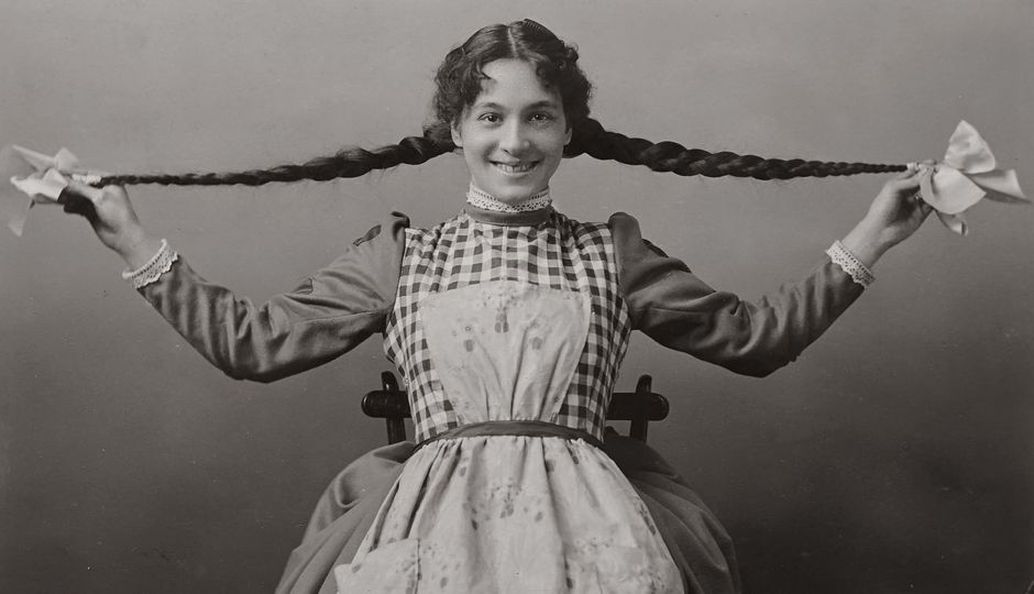 Wide ribbon bow tied above a long plait